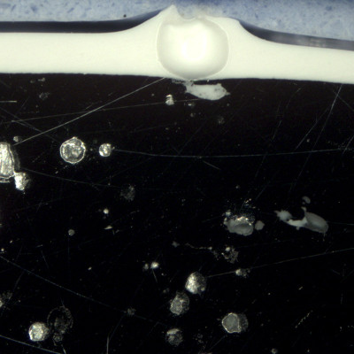 Metallgraphisches Schliffbild durch Loch in Pulverbeschichtung über Randporen im Zinkdruckguss Vergr.: 50:1 (DF)