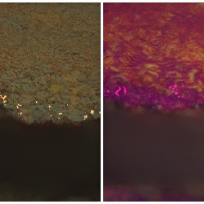 Metallographisches Schliffbild mit in Rotrost eingebetteten Kupferpartikeln; Vergr.: 500:1, DF, POL