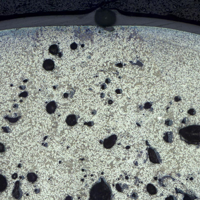 Metallographisches Schliffbild durch Löcher in Pulverbeschichtung über Randporen im Zinkdruckguss Vergr.: 50:1